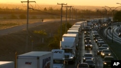 资料-2019年4月9日在墨西哥一侧等待进入美国的卡车。