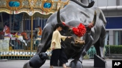 资料照:北京一家零售和批发服装商场外面的铜牛雕塑。(2018年7月9日)