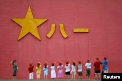 中国小学生向解放军军徽敬礼。(资料照片)