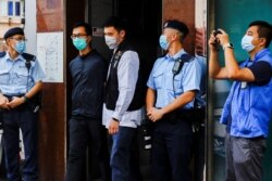 香港警察逮捕了支联会成员之一梁锦伟(左二)。(2021年9月9日)