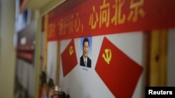 在中共十九大召开前夕北京展览馆的“砥砺奋进的五年”大型成就展中,习近平像、中共党旗和“拥护核心,心向北京”的标语。 (2017年10月10日)