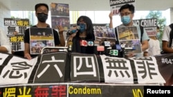 香港支联会副主席邹幸彤(中)在被指控纪念六四事件为非法组织集会后对媒体讲话。(2021年6月11日)