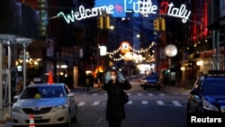 一名戴着口罩和手套的女子在曼哈顿街上行走。(2020年3月18日)