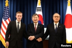 2023年12月9日,韩国国家安全顾问赵泰勇(中),与美国国家安全顾问沙利文(左)以及日本国家安全顾问秋叶武夫(右边)在新闻发布会后握手。(美联社)