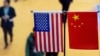 This file picture taken on November 6, 2018 shows a Chinese and US flag at a booth during the first China International Import Expo in Shanghai. - The US public's opinion of China has plummeted amid a surge in strategic and trade tensions in recent years
