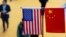 This file picture taken on November 6, 2018 shows a Chinese and US flag at a booth during the first China International Import Expo in Shanghai. - The US public's opinion of China has plummeted amid a surge in strategic and trade tensions in recent years