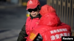 资料照:北京街头穿着红外衣的大妈担任治安志愿者。(2017年3月2日)