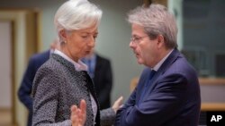 资料照:欧洲央行行长拉加德(左)在布鲁塞尔举行的欧元集团财长会议上与欧盟经济专员保罗·真蒂洛尼交谈。(2019年12月4日)