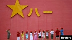 中国小学生向解放军军徽敬礼。(资料照片)