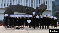 香港中文大学毕业生举起被中国拘押的12名港人的姓名牌子(2020年11月19日)