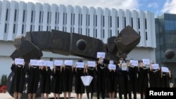 香港中文大学毕业生举起被中国拘押的12名港人的姓名牌子。(2020年11月19日)