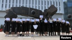 香港中文大学毕业生举起被中国拘押的12名港人的姓名牌子。(2020年11月19日)