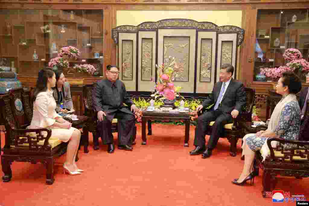 North Korean leader Kim Jong Un and wife Ri Sol Ju, and Chinese President Xi Jinping and wife Peng Liyuan meet in Beijing, China, in this undated photo released by North Korea's Korean Central News Agency (KCNA) in Pyongyang, March 28, 2018.