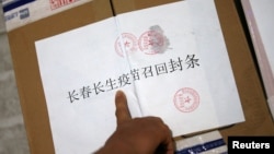 中国长春疾病控制中心的工作人员在召回的长春长生公司生产的狂犬病疫苗箱子上贴封条。(2018年7