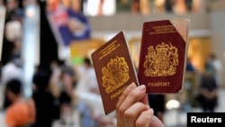 资料照:一名香港抗议者手举英国国民(海外)护照抗议港版国安法。(2020年6月1日)