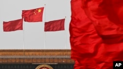 中国国旗在北京人大会堂悬挂的国徽上空飘扬。(资料照片)