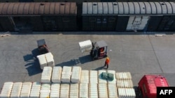 资料照片:中国江西省九江火车站的一名工人正在装卸从新疆运来的棉花。(2021年3月26日)