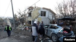 资料照片:人们站在俄罗斯空袭基辅后摧毁的房屋旁边。(2022年12月31日)