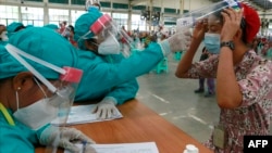 ၂၀၂၀ မေလ ၂၆ ရက်နေ့တုန်းက စက်ရုံအလုပ်သမတဦးကို COVID ရှိမရှိ အပူချိန်တိုင်းနေစဉ်