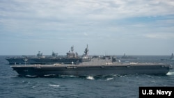资料照片:美国海军公布的照片显示,英国皇家海军“伊丽莎白女王”号航母、美国海军“卡尔·文森”号航母与日本海上自卫队“加贺”号直升机航母一道参加“海上合作伙伴关系演习”。(2021年10月17日)