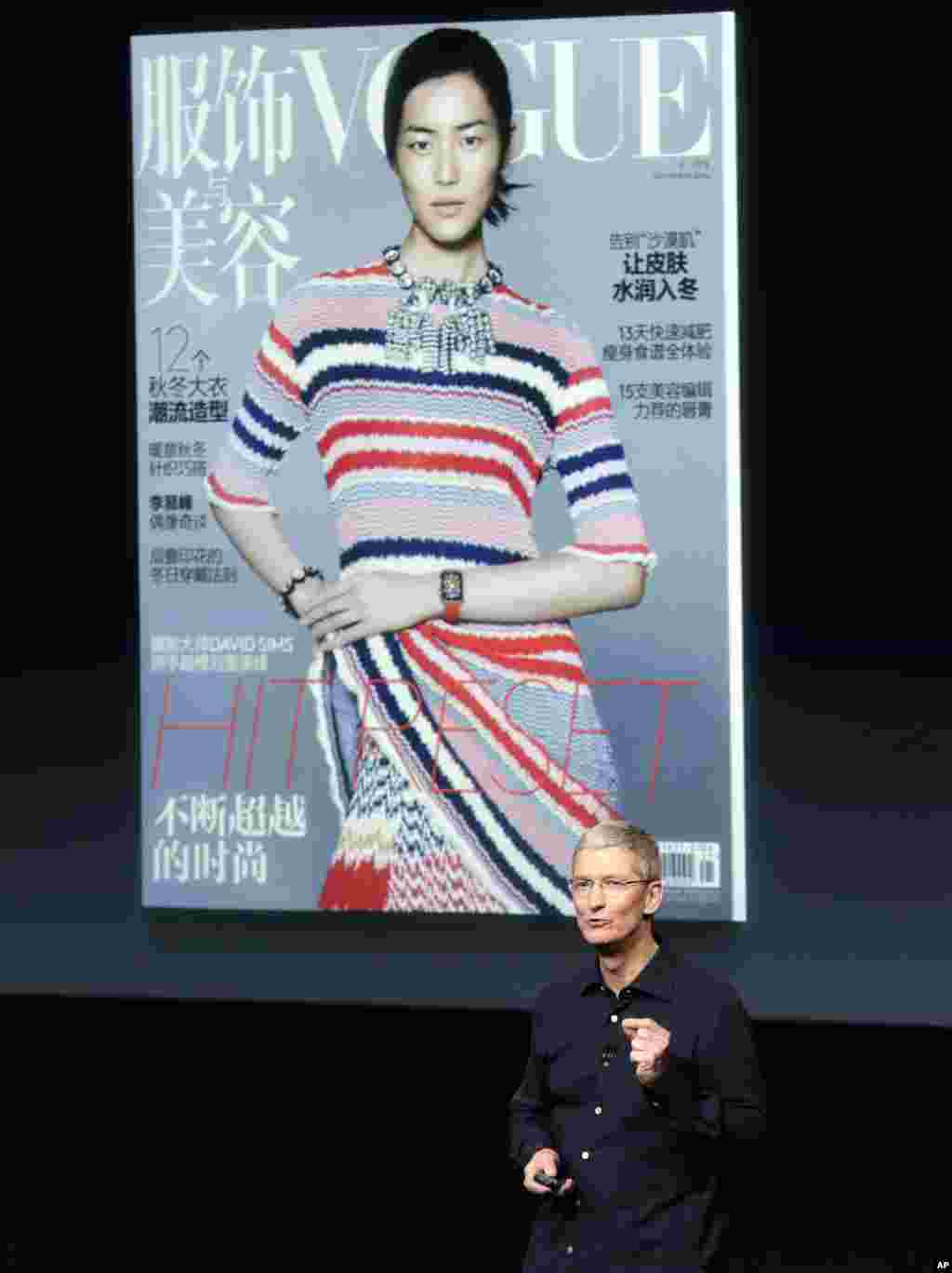 苹果公司首席执行官蒂姆·库克在在加利福尼亚州库比蒂诺的苹果总部谈论在《VOGUE服饰与美容》杂志封面上的新Apple Watch。中国超模刘雯带着苹果手表（2014年10月16日）。