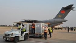 柬埔寨工人在金边国际机场从一架中国军机上卸下中国国药公司生产的新冠疫苗。(2021年2月7日)