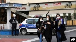 2020年2月23日,在伊朗首都德黑兰市中心商业区,警察和行人都戴着口罩。