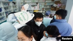 人们在杭州一家药店排队购买新冠病毒抗原检测试剂盒。(2022年12月19日)