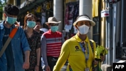 2020年1月27日,泰国导游(右)在曼谷大皇宫附近带着戴口罩的中国游客参观。