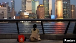 一名女子坐在上海黄浦江畔遥望浦东金融区。(2024年9月27日)