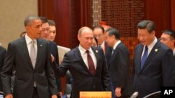 ( 前排坐起)美国总统奥巴马、俄罗斯总统普京和中国主席习近平在北京的亚太经合组织峰会上(2014年11月11日)