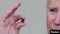 资料照:美国总统拜登手拿一枚芯片。