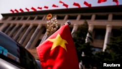 资料照:在北京人大会堂前驶过的一辆轿车上挂着一面越南国旗。(2017年5月12日)