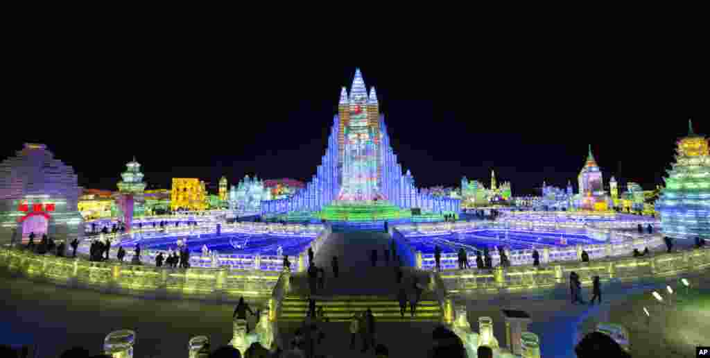 在黑龙江哈尔滨,国际冰雪节上彩色灯光辉映下的彩色广场建筑冰雕(2014年1月8日)。哈尔滨靠近寒冷的西伯利亚,冬天最低温度可降至零下35摄氏度以下。