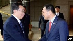 韩国代表团团长金奎显(右)在板门店与朝鲜代表团团长元东渊握手。(2012年2月12日)