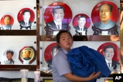 北京一个礼品摊上,习近平和毛泽东的纪念盘并列(2014年6月4日)