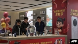 消费者在北京的一家电子零售店购买智慧型手机。中国经济面临的一大挑战是如何刺激内需。(法新社:2025年1月15日)