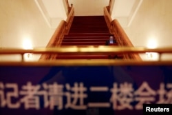 在全国人大会议投票表决通过修宪案后,一名记者坐在北京人大会堂的台阶上工作。(2018年3月11日)