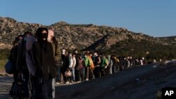 Di dân Trung Quốc chờ được sàng lọc sau khi vượt biên giới Mexico ngày 8/5/2024, gần Jacumba Hot Springs, California.
