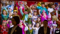 这幅照片是新疆乌鲁木齐打击恐怖主义和极端主义的展览厅。导游身后的大幅照片上是身着本民族服装的新疆各少数民族。(2021年4月21日 )