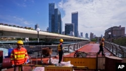 资料照片:工人在上海某地整修一座高架人行天桥。(2024年10月9日)