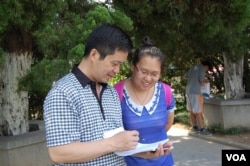 宋石莹(女)在向路人做问卷调查(美国之音林森拍摄)
