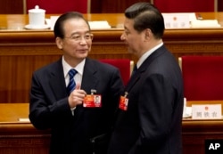 时任中国总理的温家宝与习近平交谈。(2012年3月11日)