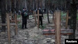 警察在新近收复的伊久姆镇附近的乱葬坟场进行检查。(2022年9月16日)