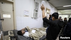2024年12月28日,以色列军队袭击了加沙北部的卡迈勒阿德万医院(Kamal Adwan hospital)。图为一名受伤的巴勒斯坦人从该医院撤离,一名男子正在使用电话。