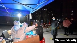 天津医护人员给市民进行新冠病毒核酸检测。(2022年1月12日)