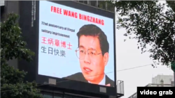 在台湾标志性建筑“台北101”大楼前十字路口的大型霓虹灯电子广告牌上播出庆祝王炳章生日的图片。(2024年12月28日,视频截图)