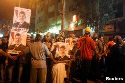 2013年7月30日,在埃及首都开罗东面的一个清真寺附近,被推翻的总统穆尔西的支持者和宗教学者参与反对军方的示威集会。