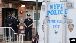 Polisi berdiri di depan gedung tempat terjadinya penembakan yang menewaskan banyak orang di wilayah Queens, New York, Selasa, 31 Juli 2018. (Seth Wenig/AP)