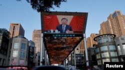 资料照片:中国北京街头一处大屏幕正在播放中国共产党第二十届三中全会的报道。(2024年7月18日)